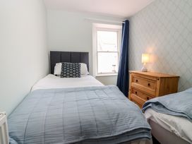 A bedroom with two beds and wooden furniture at 21A High Street in Jedburgh