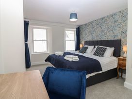 A bedroom with a bed and windows at 21A High Street Jedburgh