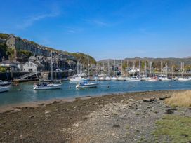 A harbor with moored sailboats and houses on a hillside at Sailing Home in Porthmadog