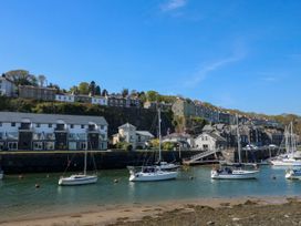 A harbor with sailboats on water and buildings on a hill in the background at Sailing Home in Porthmadog