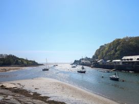 A river with sailboats and buildings along the shore at Sailing Home in Porthmadog