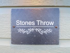 A stone sign with the text Stones Throw mounted on a light colored wooden wall at Stones Throw in Marston near Barkston