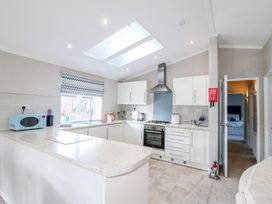 A kitchen with white cabinets a microwave and a gas stove at Stones Throw in Marston near Barkston