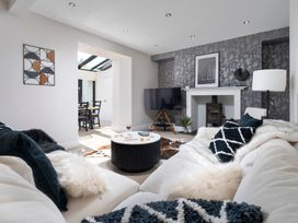A living room with a coffee table and television at Rosemount Boutique in Windermere