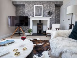 A living room with a television, coffee table, and fireplace at Rosemount Boutique in Windermere