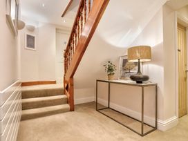 A staircase with a console table and lamp in a hallway at Rosemount Boutique Windermere
