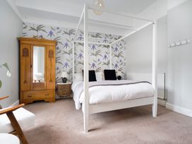 A bedroom with a four-poster bed and a wardrobe at Rosemount Boutique in Windermere