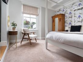 A bedroom with a bed and an armchair at Rosemount Boutique in Windermere