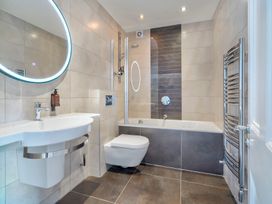 A bathroom with a sink, toilet, bathtub, and shower at Rosemount Boutique in Windermere