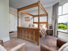 A bedroom with a four-poster bed and wardrobe at Rosemount Boutique in Windermere