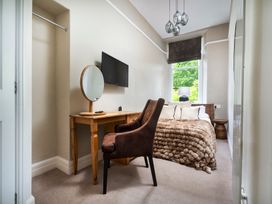 A bedroom with a bed and chair at Rosemount Boutique in Windermere
