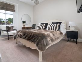 A bedroom with a bed and armchair at Rosemount Boutique, Windermere