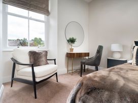 A bedroom with a chair and table at Rosemount Boutique in Windermere