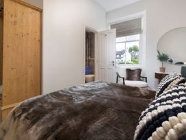 A bedroom with a bed and a wardrobe at Rosemount Boutique in Windermere