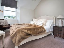 A bedroom with a bed and chair at Rosemount Boutique in Windermere