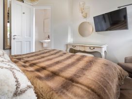 A bedroom featuring a bed, television, and a vanity at Rosemount Boutique in Windermere