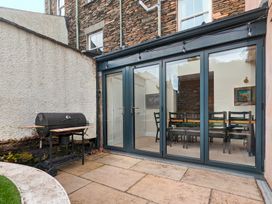 A dining room with glass doors and a grill outside at Rosemount Boutique in Windermere