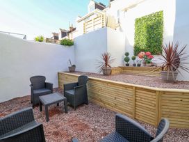 A garden with seating and planters at Hollycombe in Ilfracombe