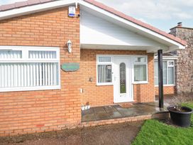 The front entrance of a brick house with white door and windows at Greenacres in Towyn