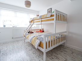 A bedroom with a white bunk bed and stuffed animals on the beds at Greenacres in Towyn