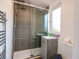 A bathroom with a glass shower enclosure sink with cabinet toilet and frosted window at Cuckoo in Ramsey Huntingdon