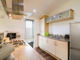 A kitchen with a gas stove microwave kettle toaster refrigerator and sink at Kingfisher in Ramsey Huntingdon