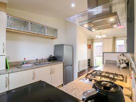 A kitchen with a sink dish soap toaster refrigerator gas stove kettle and mugs at Kingfisher Ramsey Huntingdon