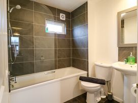A bathroom with a bathtub shower toilet and sink at Kingfisher Ramsey Huntingdon