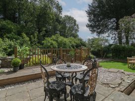 A garden with a table and chairs at Court House Cottage in Gatcombe near Blakeney