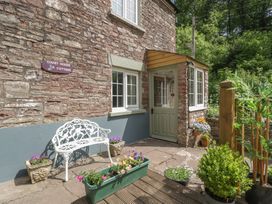 An outdoor area with a bench and flower pots at Court House Cottage Gatcombe near Blakeney
