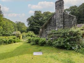 A garden area with stonework and plants at Glandwr Cottage Llanbedr