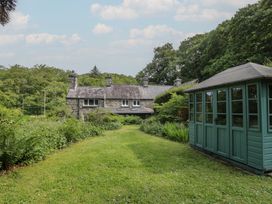 A garden with a house and a shed at Glandwr Cottage in Llanbedr