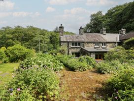A cottage with a garden and stone pathway at Glandwr Cottage in Llanbedr