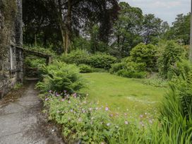 A garden with pathway and flowers at Glandwr Cottage in Llanbedr