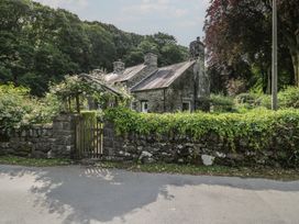 A house with a stone wall and garden at Glandwr Cottage in Llanbedr