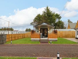 A small cabin with wooden fencing and green lawn in front at Binevanagh Cabin in Magilligan near Castlerock