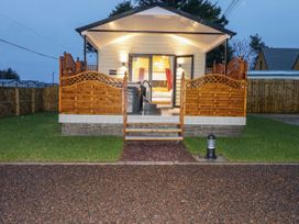 A small cabin with a wooden porch and steps leading up to a glass door at Benone Cabin in Magilligan near Castlerock