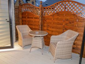 A small outdoor seating area with two wicker chairs and a wicker table with an ashtray on it at Benone Cabin in Magilligan near Castlerock