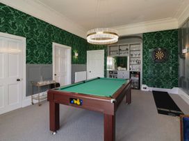 A game room with a pool table dartboard and shelves with glasses at Buckland House and Annex Lower Durston near Taunton