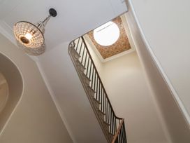 A staircase with decorative railing under a ceiling light fixture and a skylight with floral patterned border at Buckland House and Annex Lower Durston near Taunton