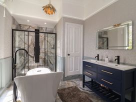 A bathroom with a freestanding bathtub a double sink vanity and a glass shower enclosure at Buckland House and Annex Lower Durston near Taunton