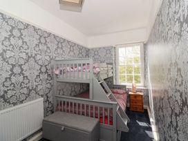 A bedroom with a bunk bed next to a window and a wooden nightstand at Buckland House and Annex Lower Durston near Taunton