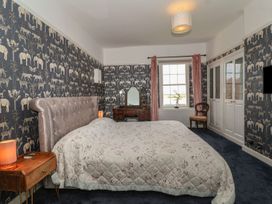 A bedroom with a bed bedside tables a vanity table a chair and animal print wallpaper at Buckland House and Annex Lower Durston near Taunton