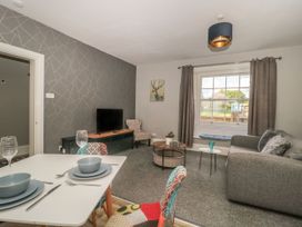 A living room with a sofa dining table and television at Buckland House and Annex in Lower Durston near Taunton