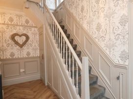 A hallway with a staircase and decorative wallpaper at 59 Moorland Road, Scarborough