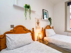 A bedroom with two beds and a lamp at 59 Moorland Road in Scarborough