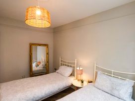 A bedroom with two beds and a mirror at 59 Moorland Road Scarborough