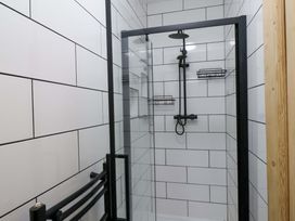 A shower with glass door and tiled wall at 59 Moorland Road Scarborough