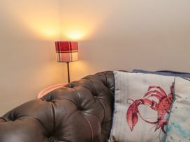 A sofa with a lobster pillow and a lamp at 1 Albion Place in Whitby