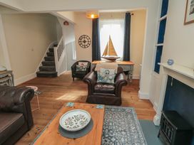 A living room with a sofa, coffee table, and a staircase at 1 Albion Place, Whitby